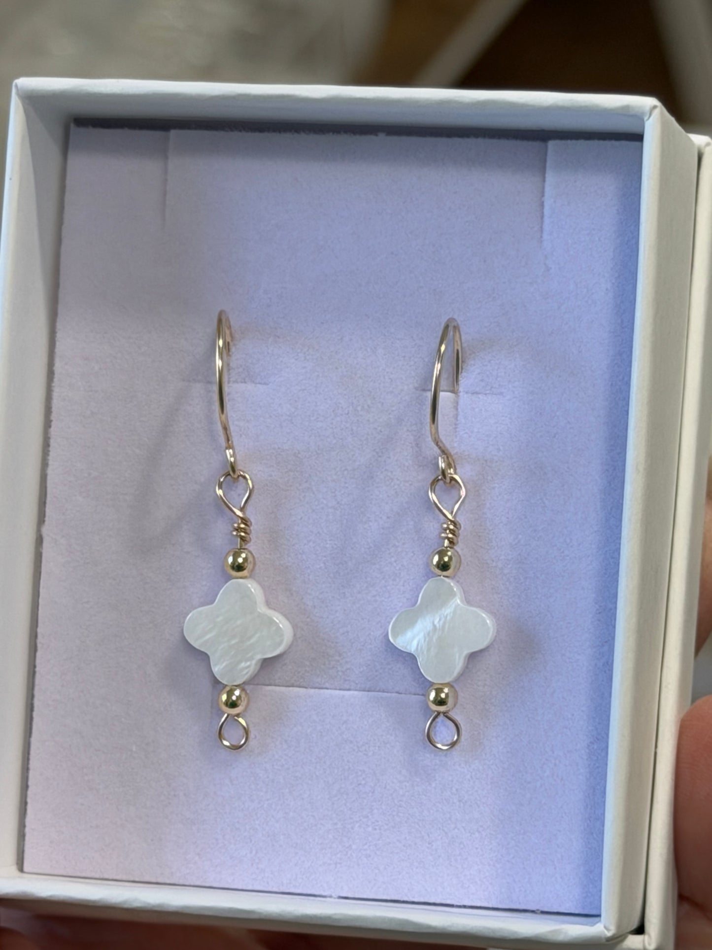 Handcrafted mother-of-pearl clover earrings with 14k gold-filled wire displayed in jewelry box in Destin, Florida
