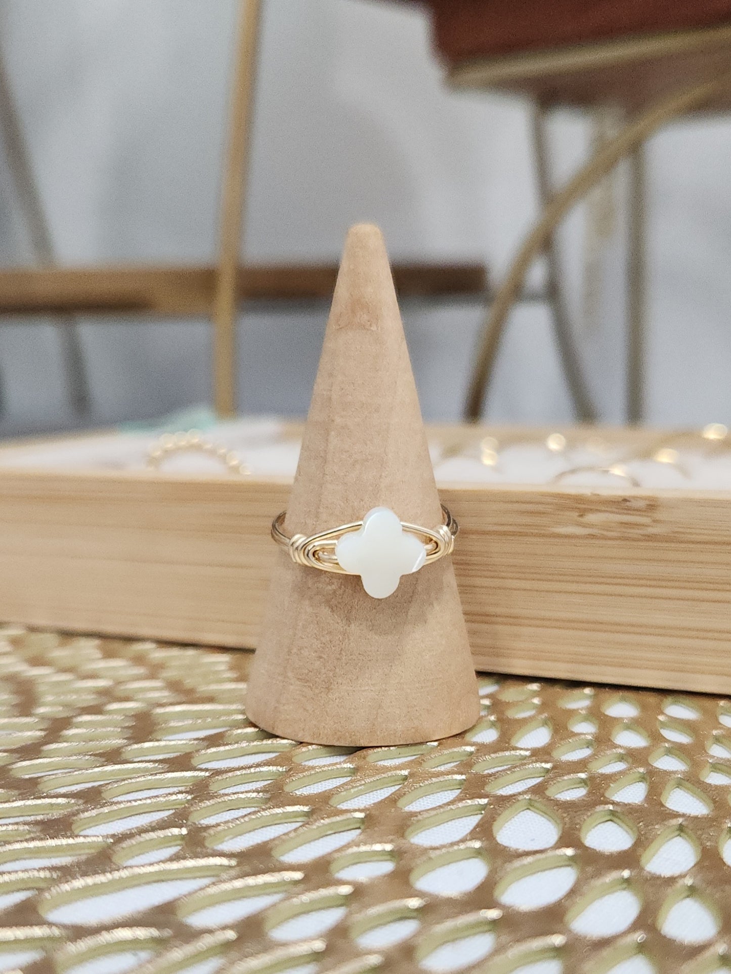 Handcrafted mother-of-pearl clover ring displayed in a styled jewelry setting