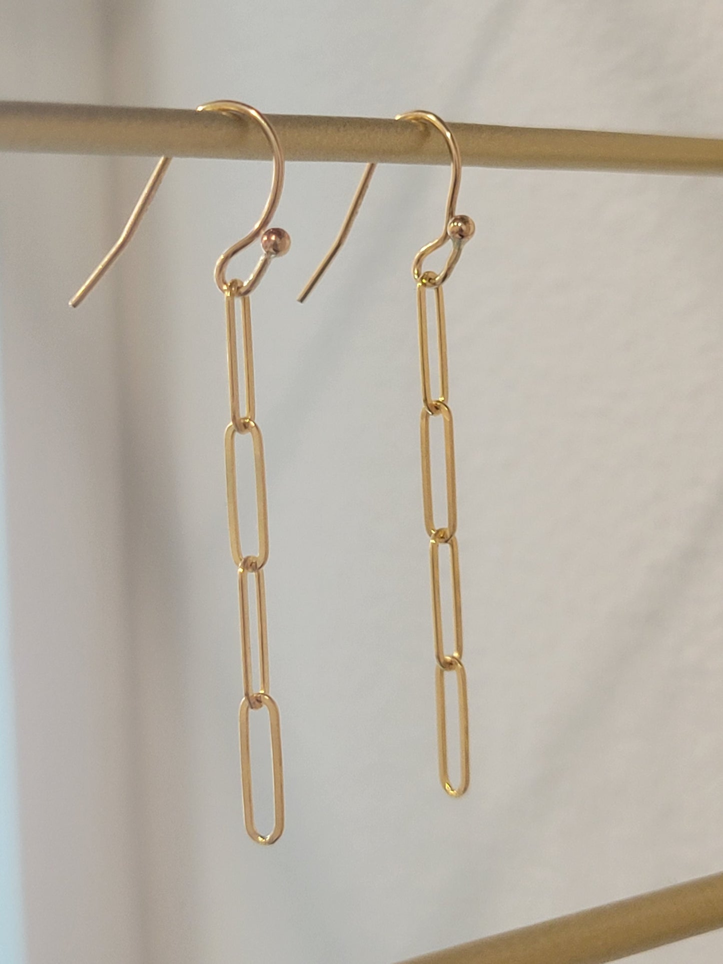 Gold-filled paperclip chain earrings shown hanging, featuring sleek modern link design