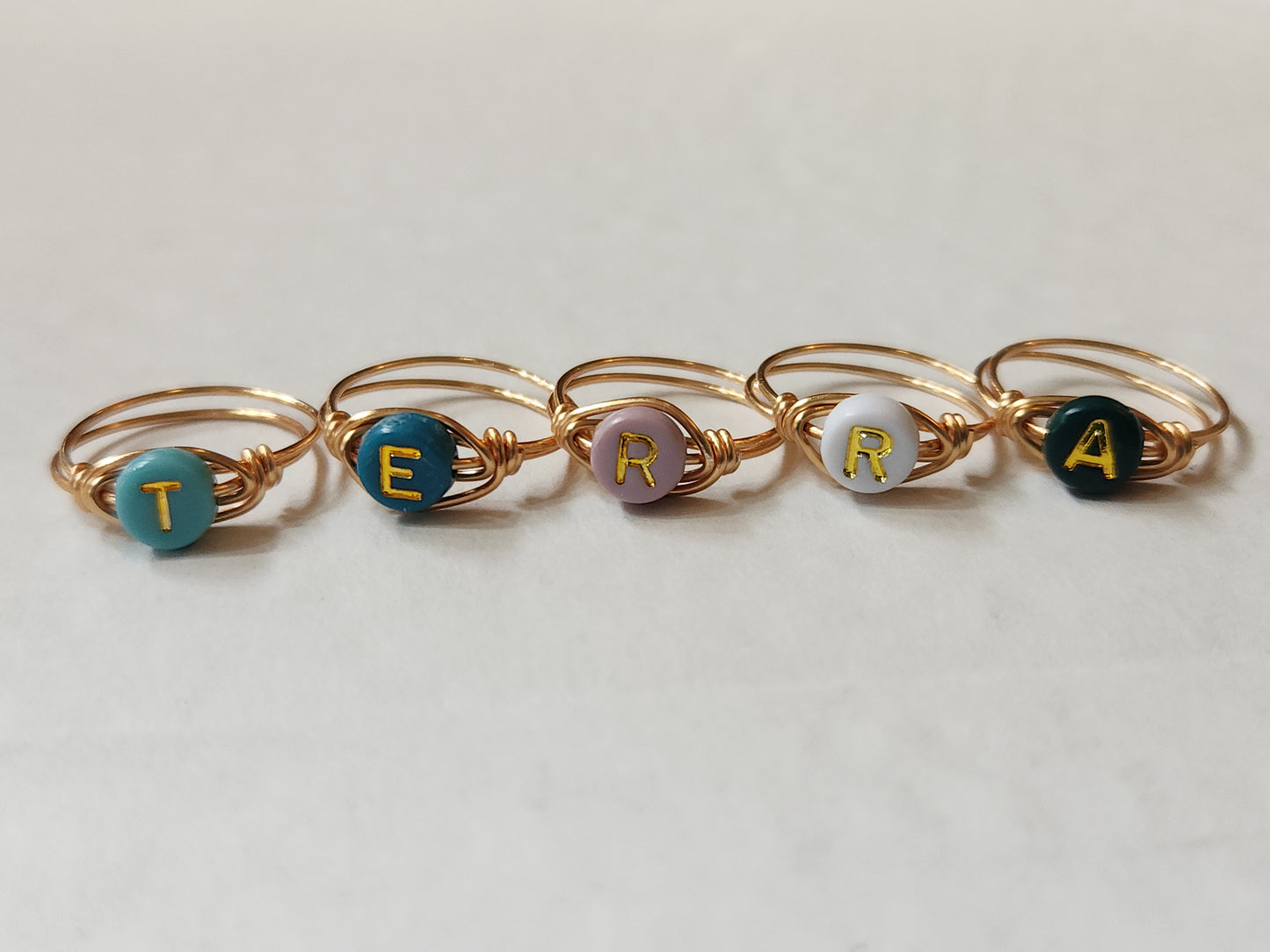 Custom initial ring handcrafted with gold-filled wire shown in a flat lay arrangement