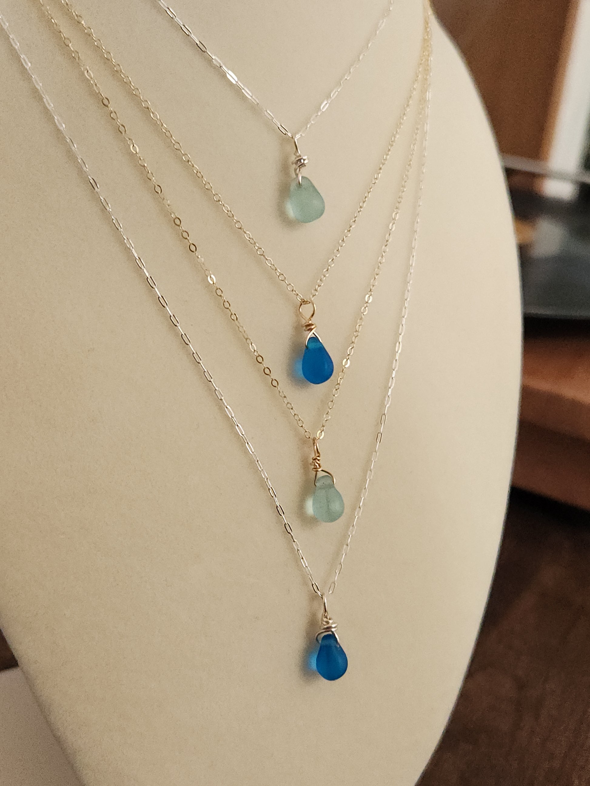 Light blue Destin sea glass necklace worn on a mannequin with 14k gold-filled chain