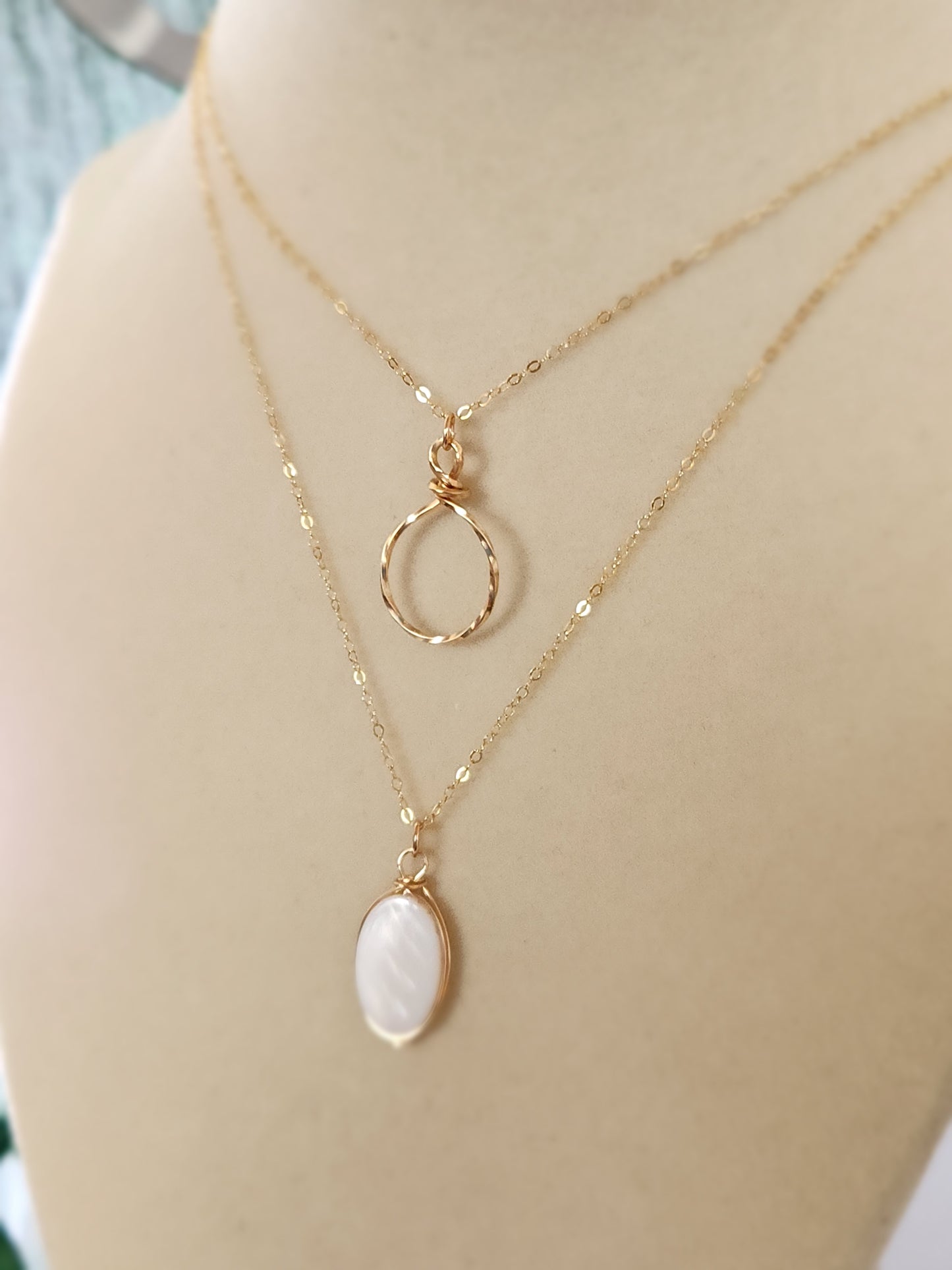 Gold-filled hammered circle necklace shown worn on a mannequin bust