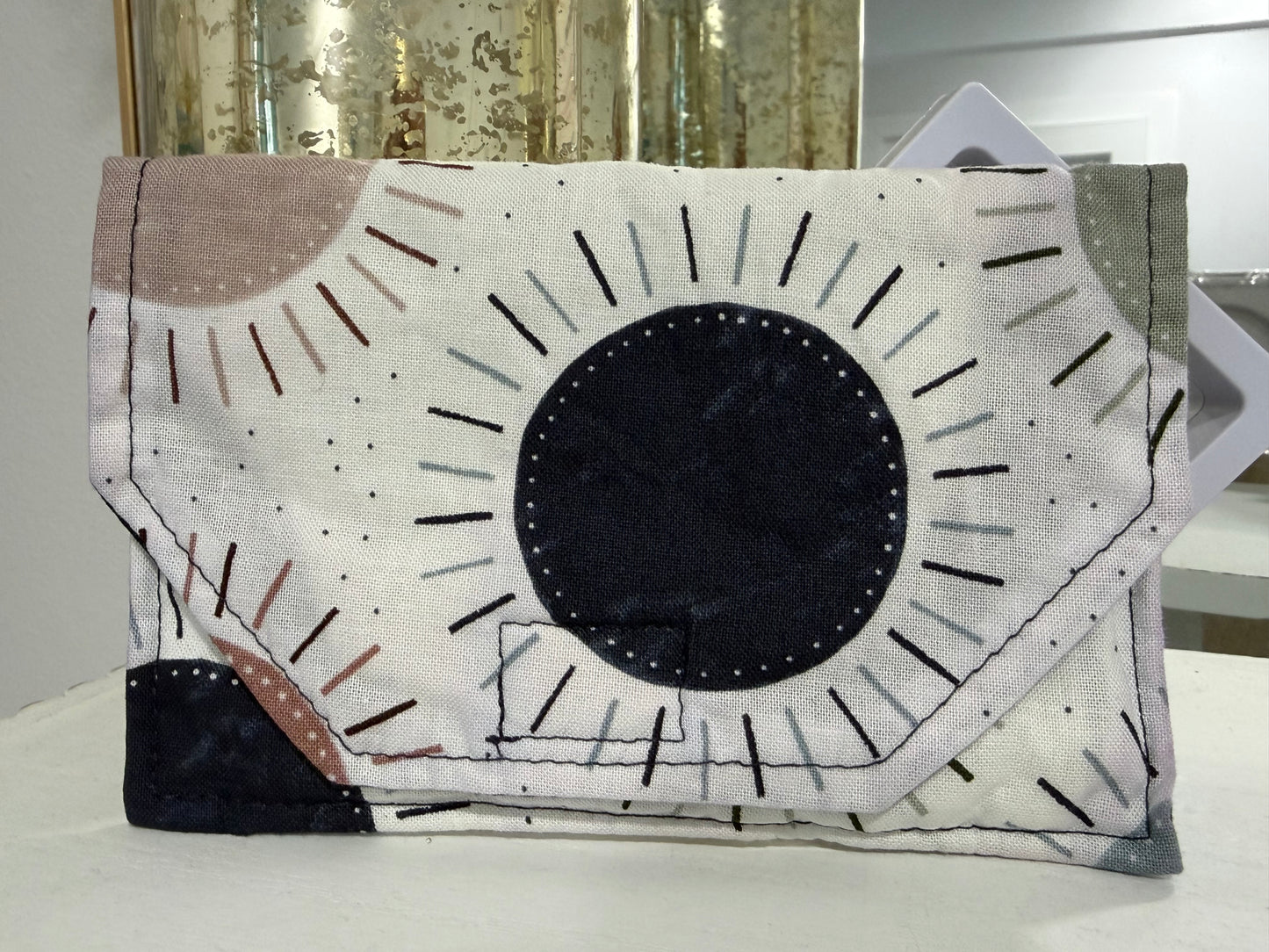 Handmade fabric wallet featuring a modern sunburst design in soft neutral tone