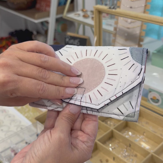 Video showing a handmade fabric wallet with a modern sunburst design being held and opened