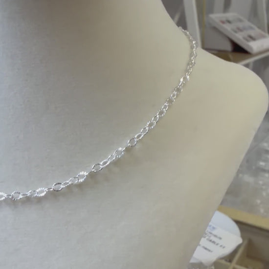 Video showing a sterling silver sunburst chain necklace worn on the neck, highlighting its light-catching texture