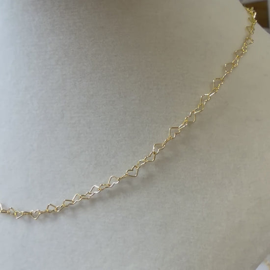 Video showing a 14k gold-filled heart link necklace worn on the neck, highlighting the open-heart chain design