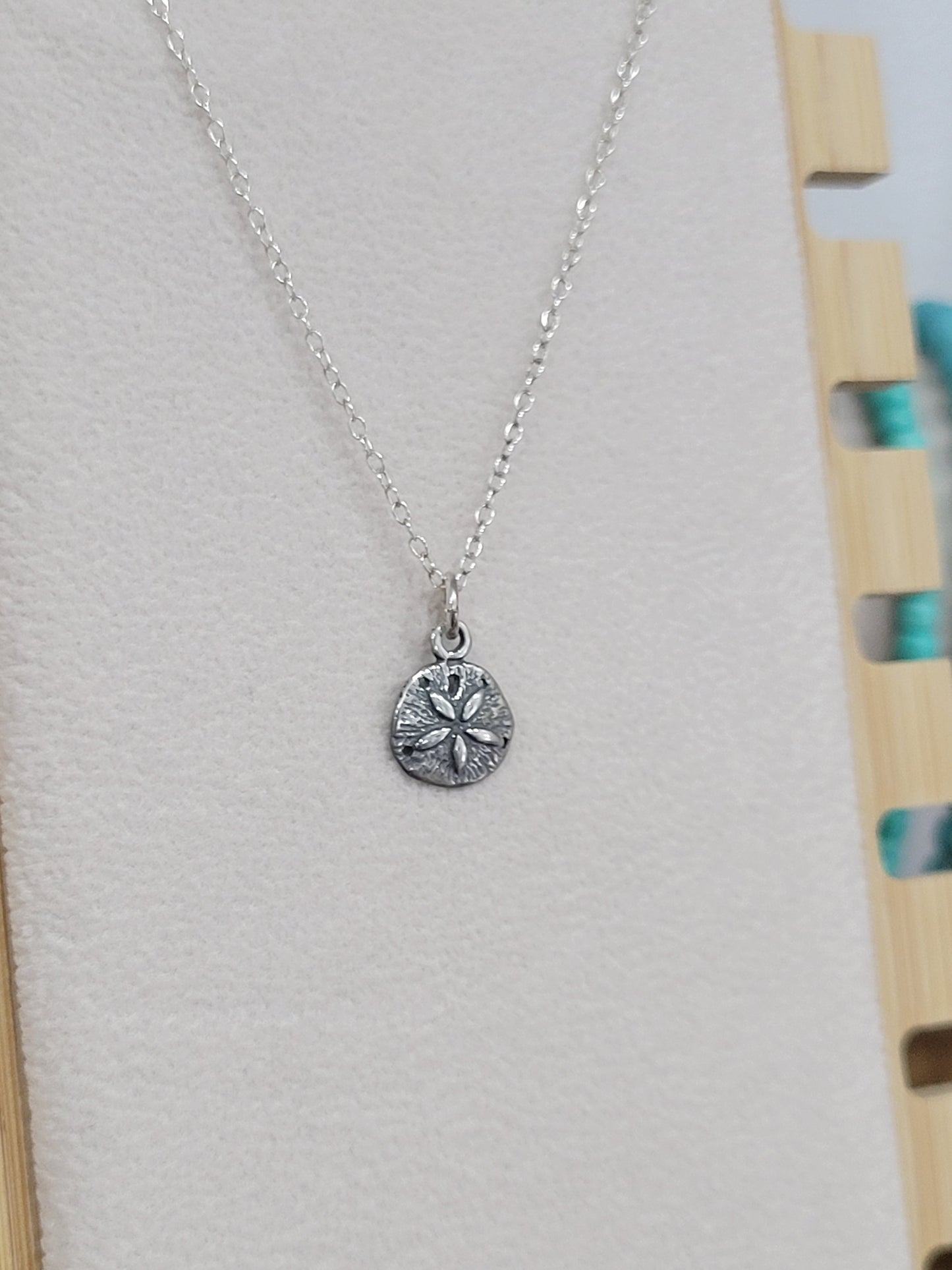 Sterling silver sand dollar necklace with ocean-inspired charm on a delicate silver chain