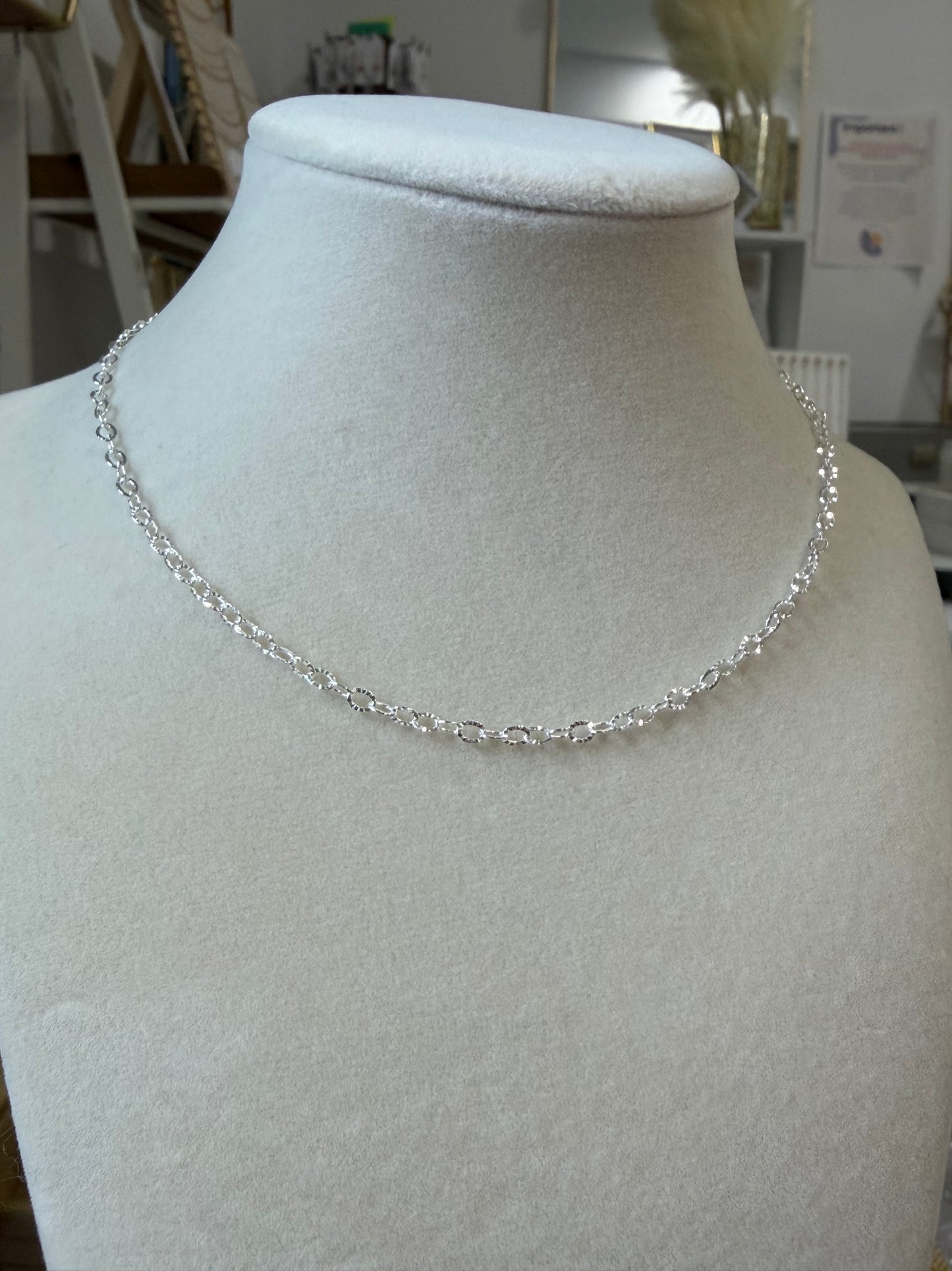 Sterling silver sunburst chain necklace shown styled alone for a minimalist look