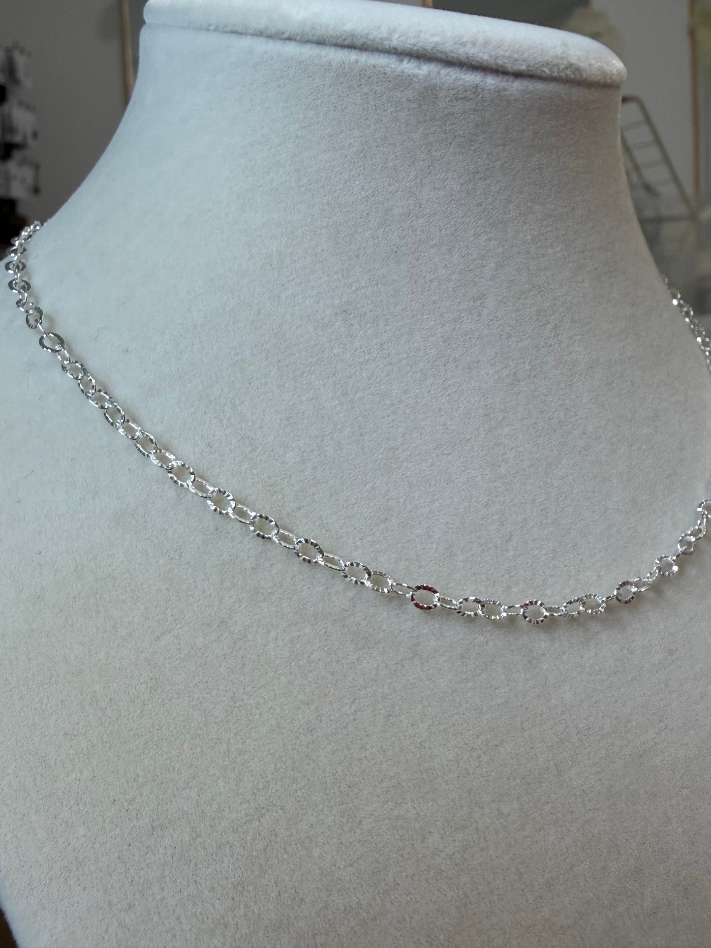 Sterling silver sunburst chain necklace displayed on a jewelry bust