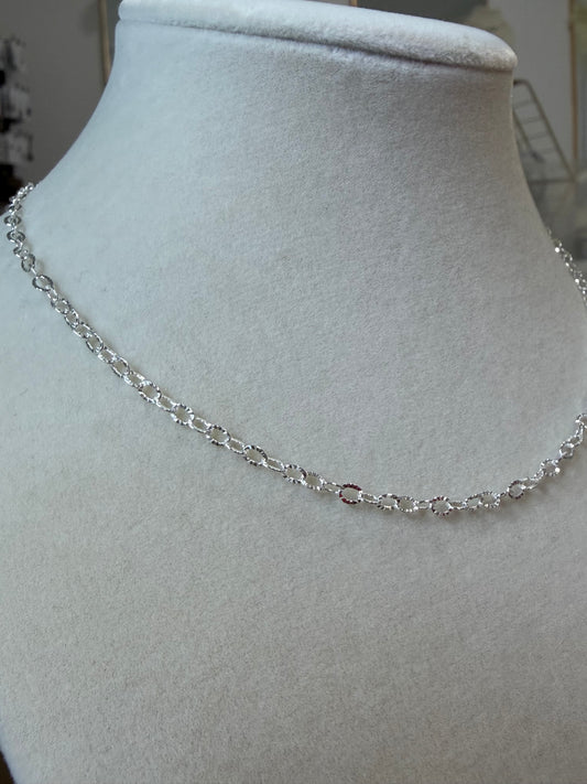 Sterling silver sunburst chain necklace displayed on a jewelry bust