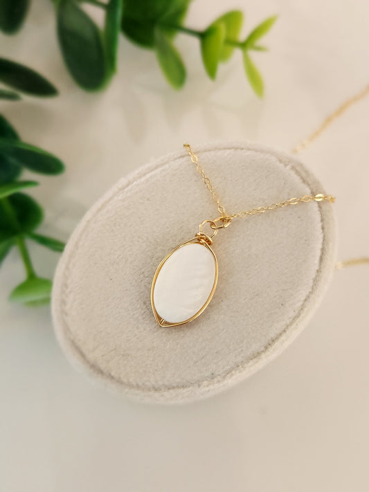 Handcrafted freshwater pearl necklace set in 14k gold-filled wire on a jewelry display