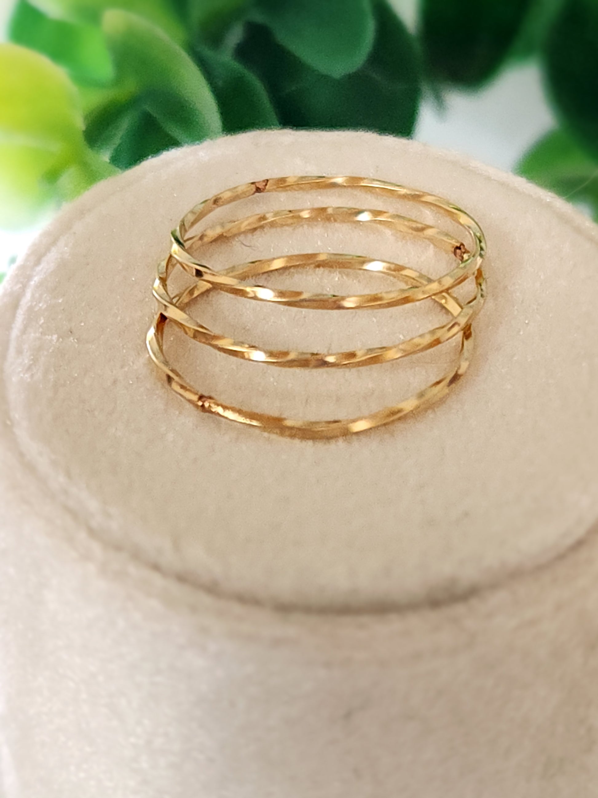 14k gold-filled tide stacking rings with hammered texture stacked together on a display